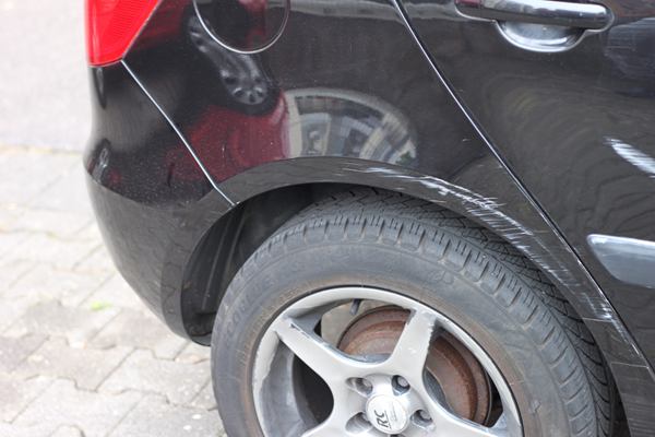 Schaden am hinteren Radlauf eines schwarzen Fahrzeugs