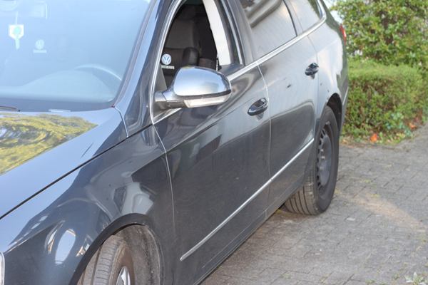 Schaden an der Fahrerseite eines dunkelgrauen Kombis